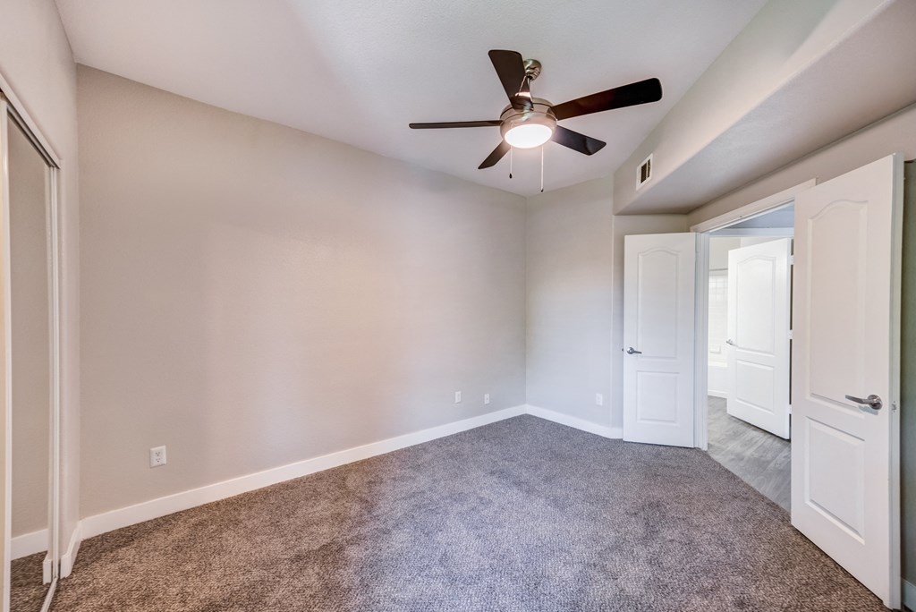 a bedroom with a ceiling fan and closet