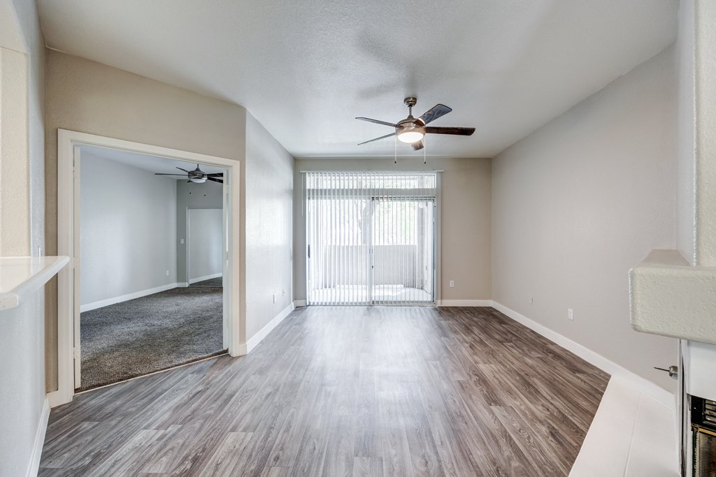 a living room with hardwood floors and a ceiling fan