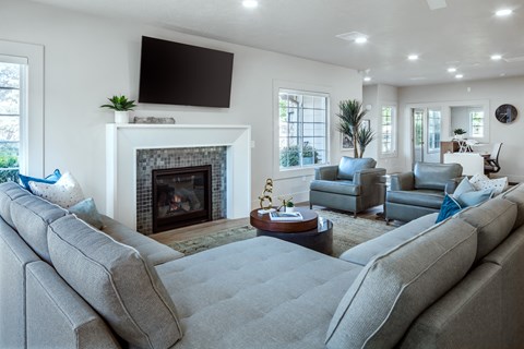 A living room with a grey sofa and a fireplace.