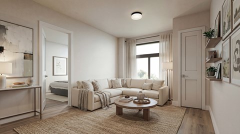 A well-lit living room with a couch, coffee table, and a large window.
