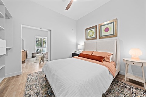 a bedroom with a large bed and a closet ceiling fan