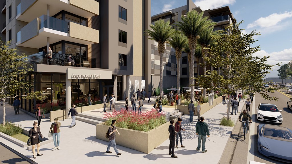 A street view of a modern building with people walking around and cars parked on the side.