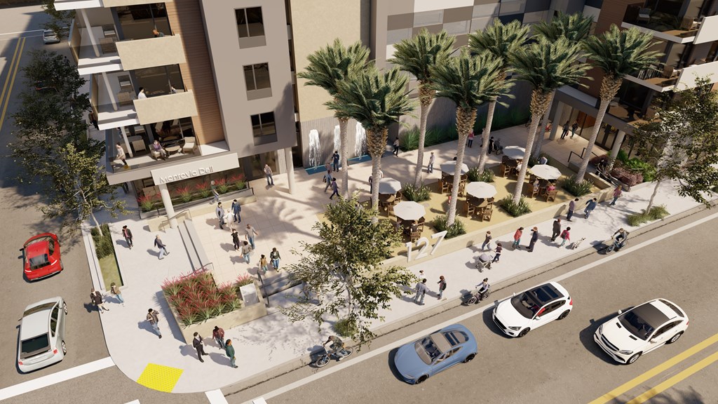 A street view of a busy intersection with cars and pedestrians.