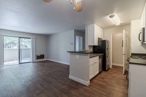 A kitchen with white cabinets and a black fridge.