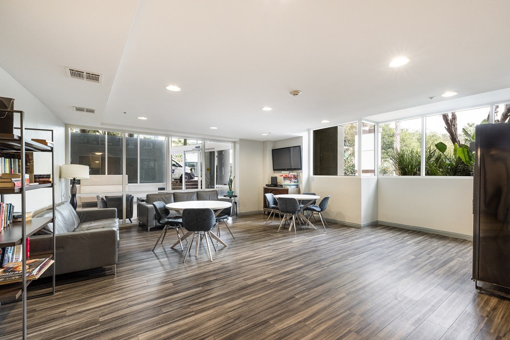 A modern living room with a wooden floor and a large window.