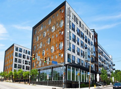 A modern building with a brown and white facade is situated on a street corner.