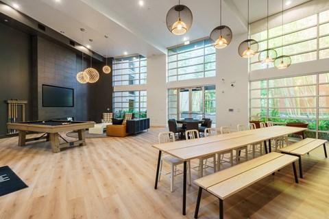 a communal room with tables and chairs and a pool table