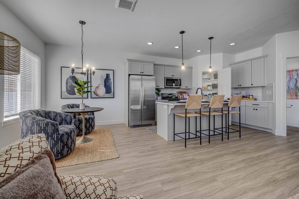 A modern kitchen with a dining area and a living room.
