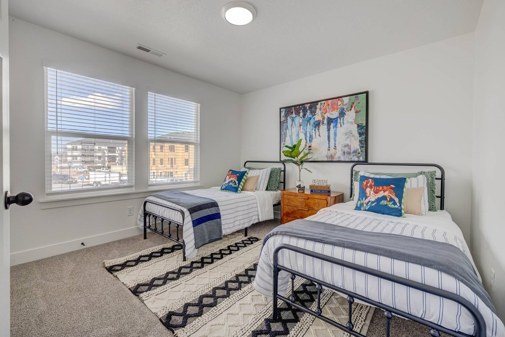 A bedroom with two beds and a painting on the wall.