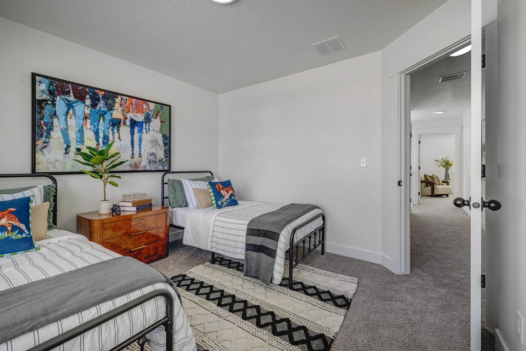 A bedroom with two beds and a painting on the wall.