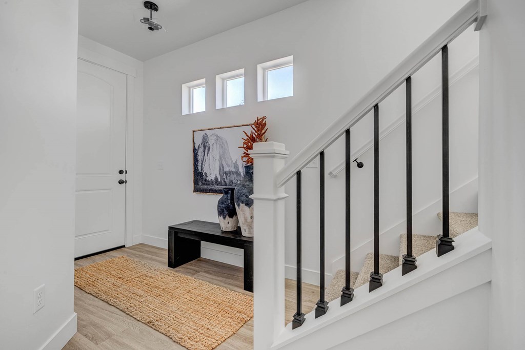 A staircase with a black railing and a white handrail.