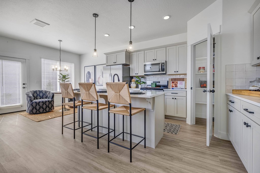 A kitchen with a bar area and chairs.