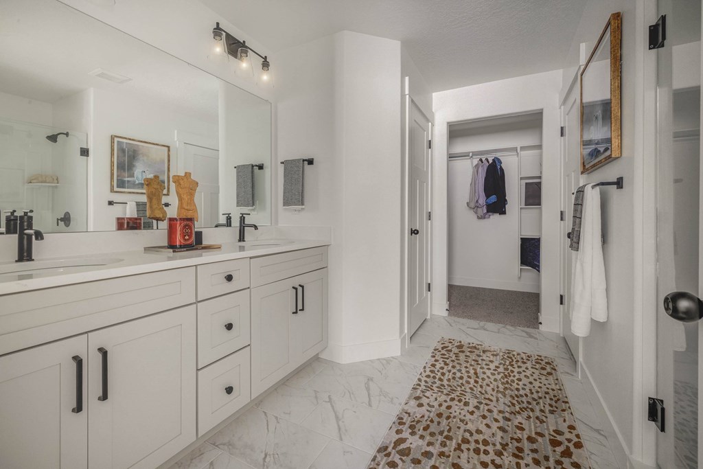 A bathroom with a marble floor mat and a white vanity.