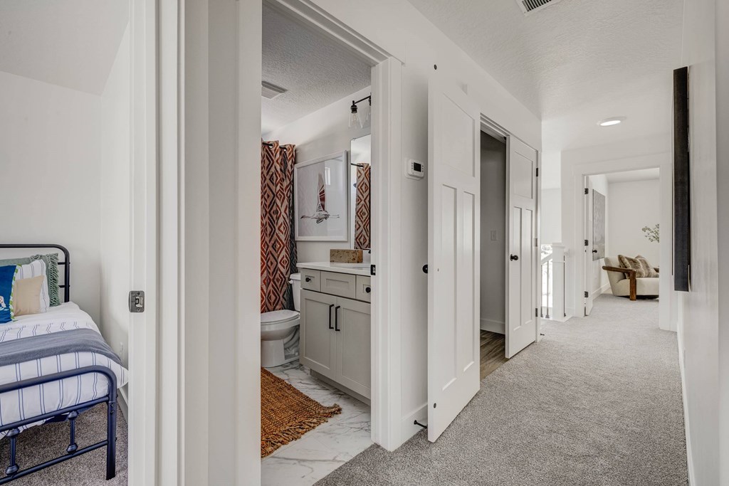 A bedroom with a bed, dresser, and mirror.