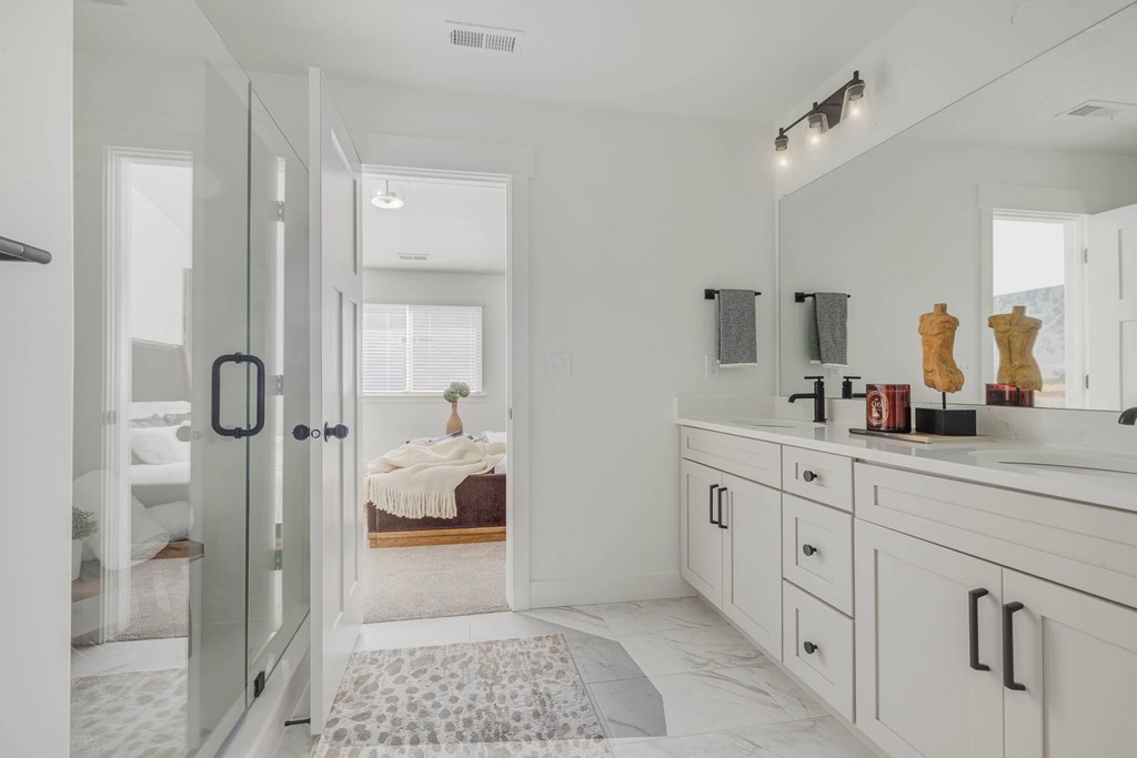 A bathroom with a white vanity and a mirror above it.