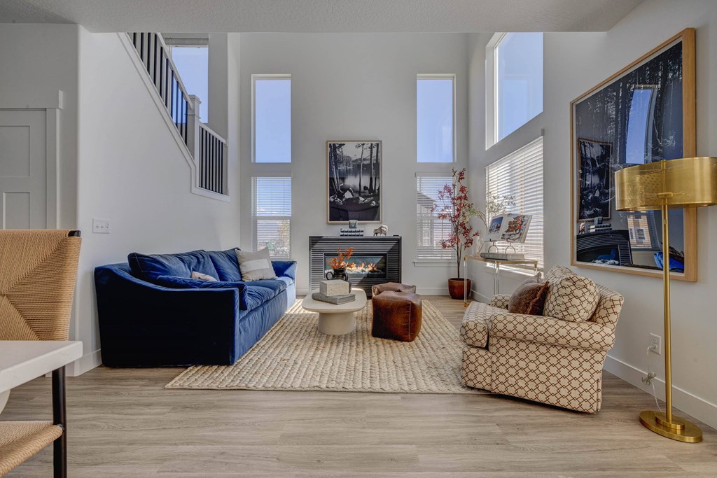 A living room with a blue couch, a patterned armchair, and a coffee table.