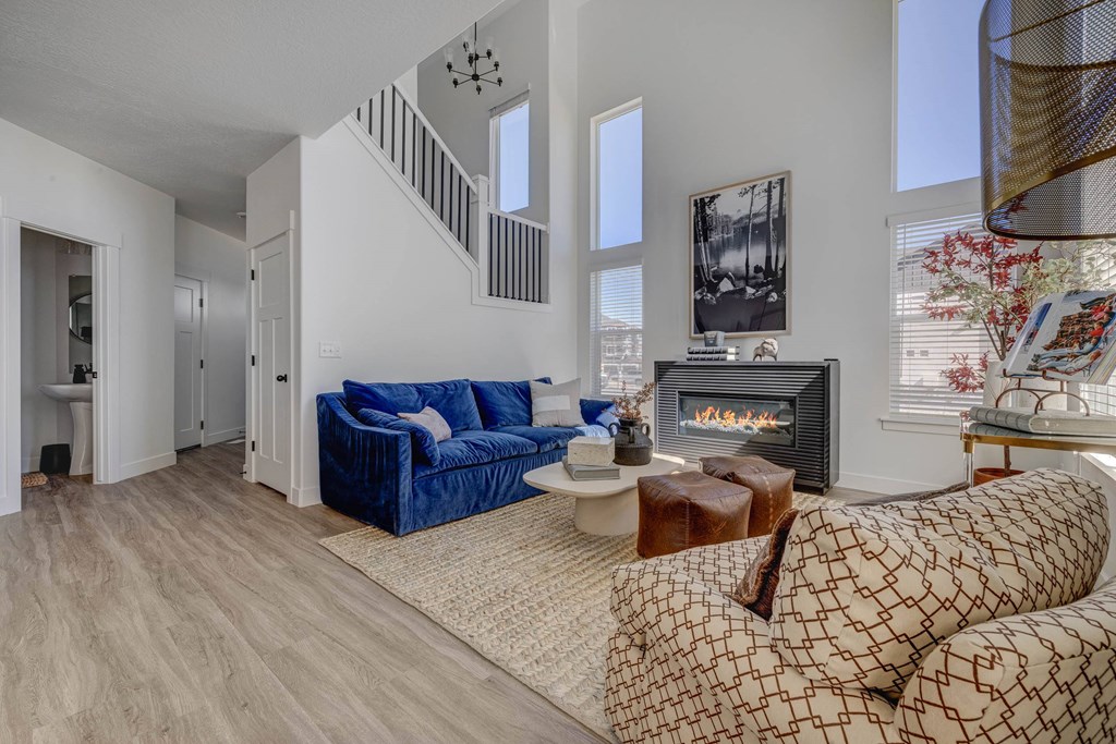 A living room with a blue couch and a fireplace.
