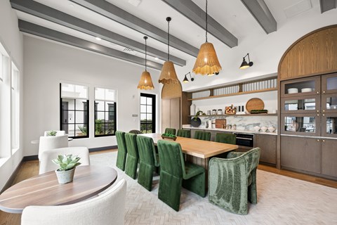A modern kitchen with green chairs and wooden furniture.