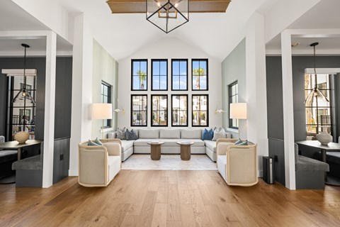 A modern living room with a large sectional sofa and a wooden floor.