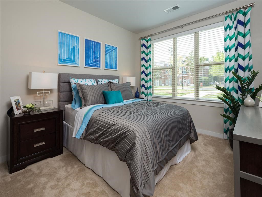 a bedroom with a large window and a bed