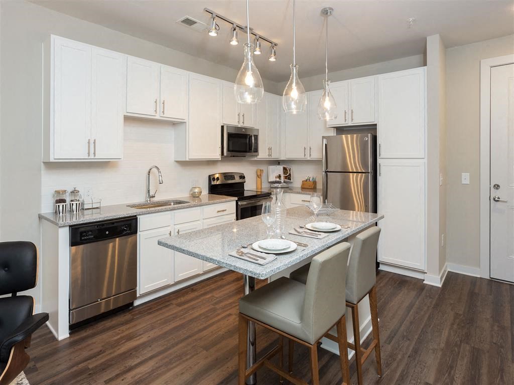 a kitchen with stainless steel appliances and a marble counter top