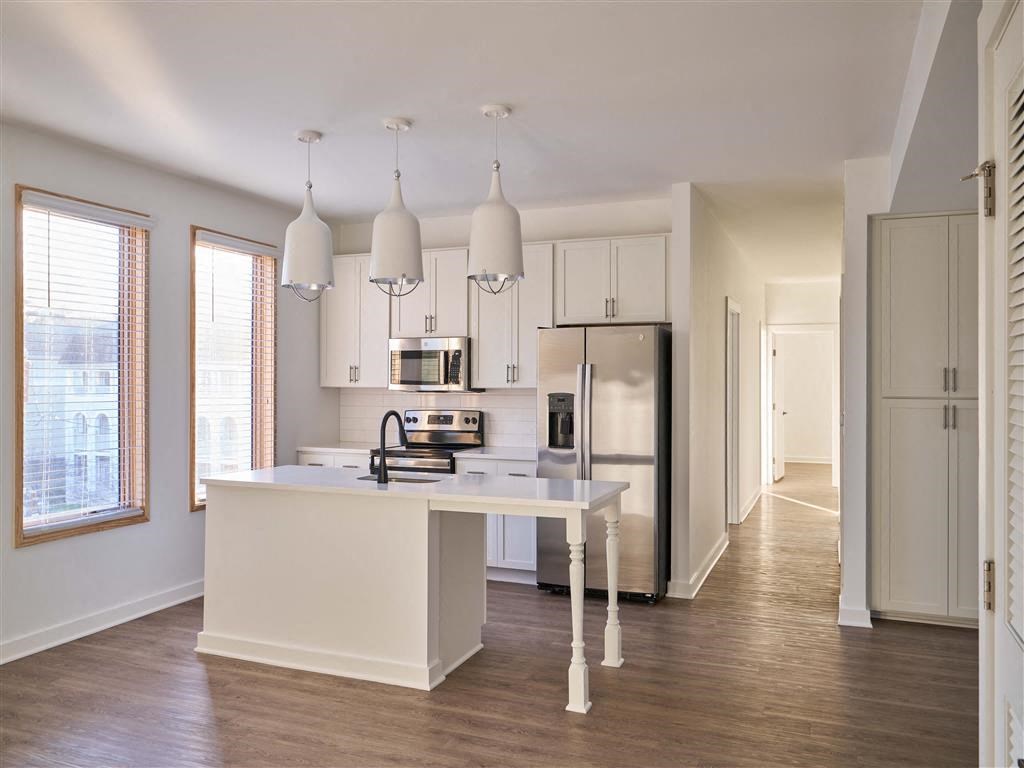 a kitchen with a white counter top and a refrigerator