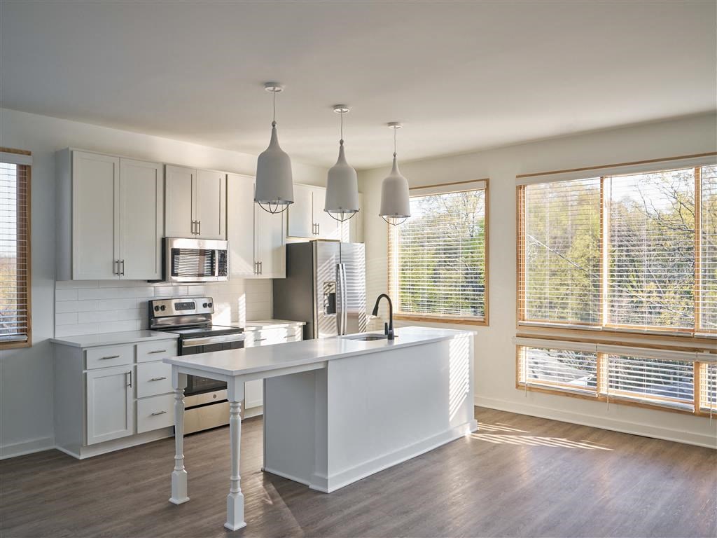 a kitchen with a large white island next to a window