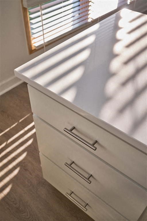 a white dresser sitting next to a window