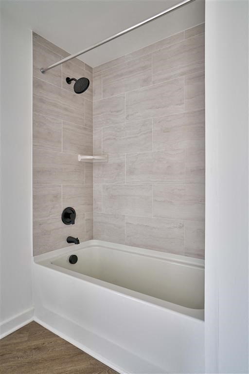 a white bath tub sitting next to a shower