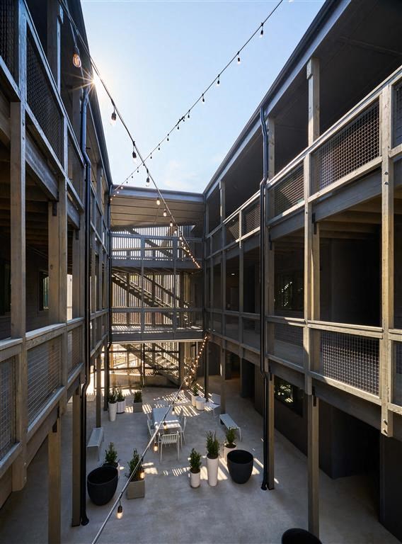 a courtyard with tables and chairs and lights hanging from the ceiling