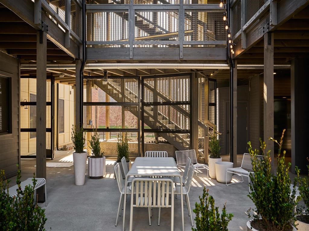 a patio with a table and chairs and a staircase in the background