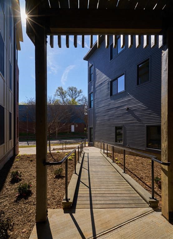 a wooden walkway with a pergola above it