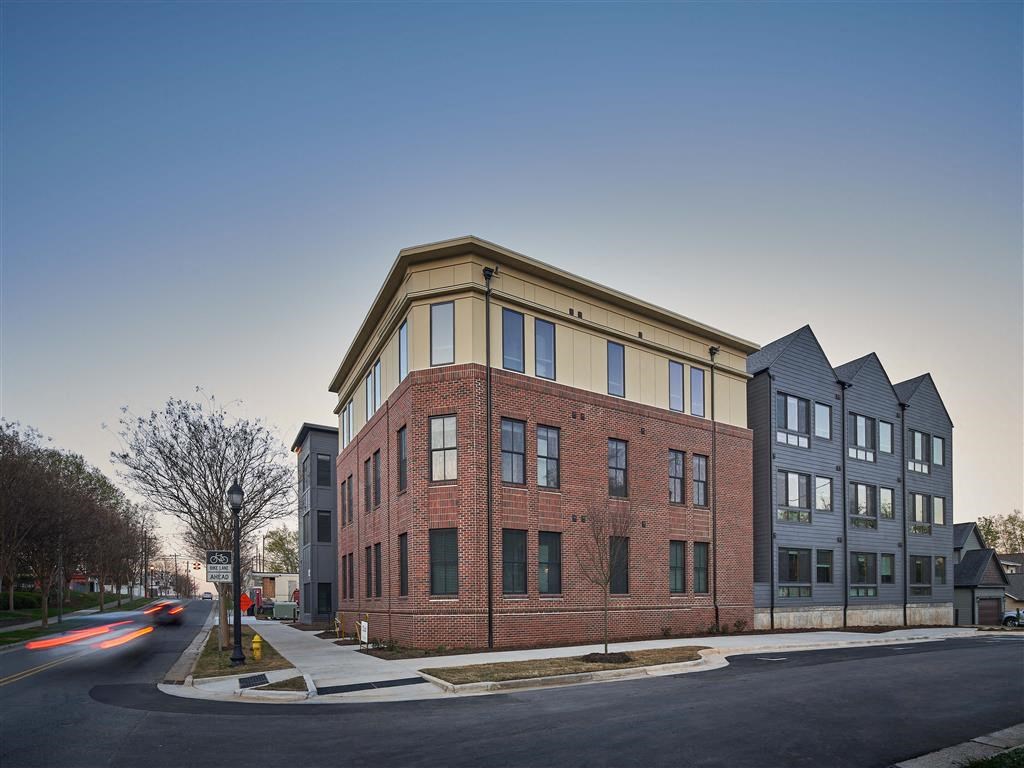a red brick building on a corner with a blue sky in the background
