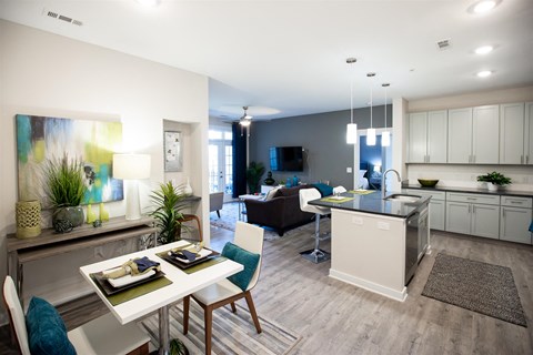 a living room and kitchen with a table and chairs