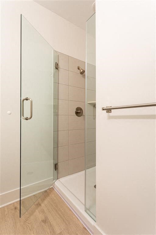 a white bathroom with a shower with glass doors