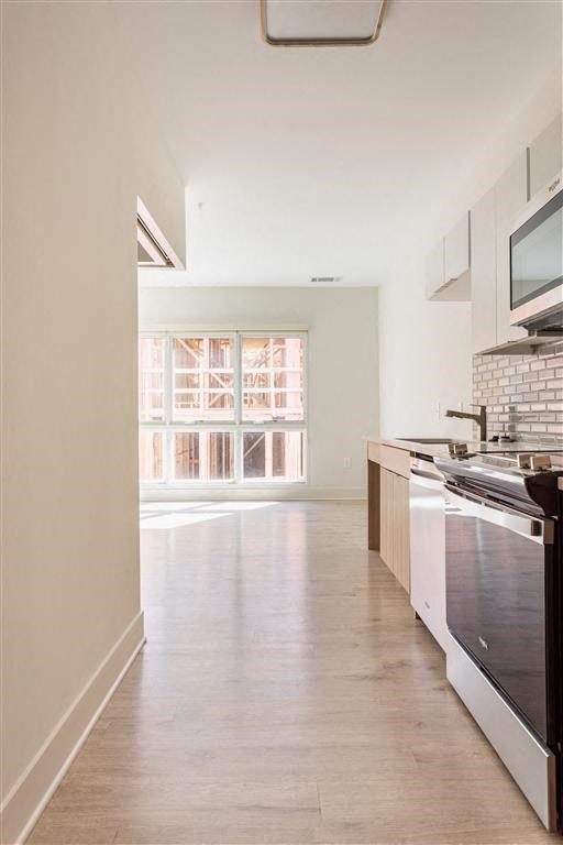 an empty kitchen with a stove and a window