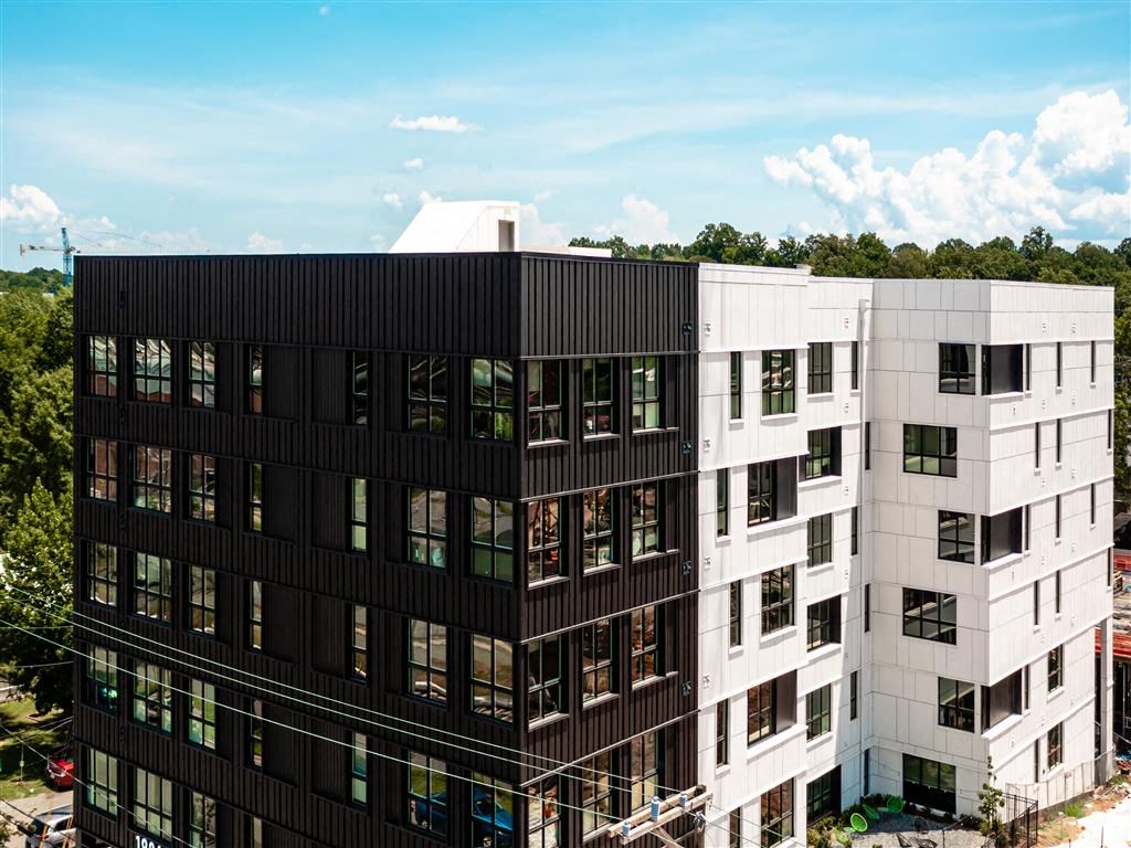 a tall building with a forest in the background