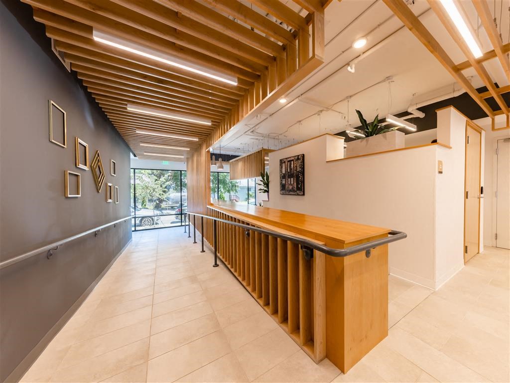 a long lobby with a bar and a glass door