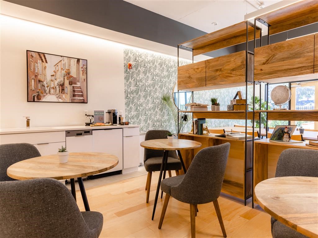 a dining room with tables and chairs and a kitchen