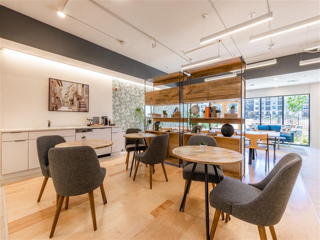 a dining room with tables and chairs and a kitchen