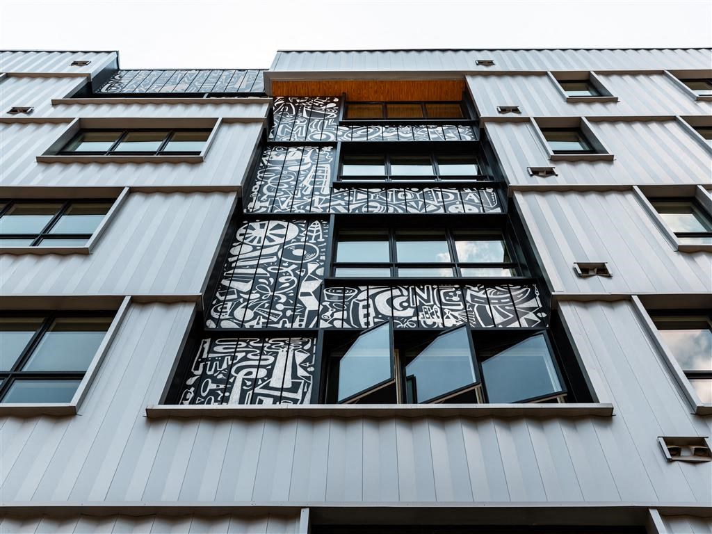 the side of a metal building with a window and graffiti on it