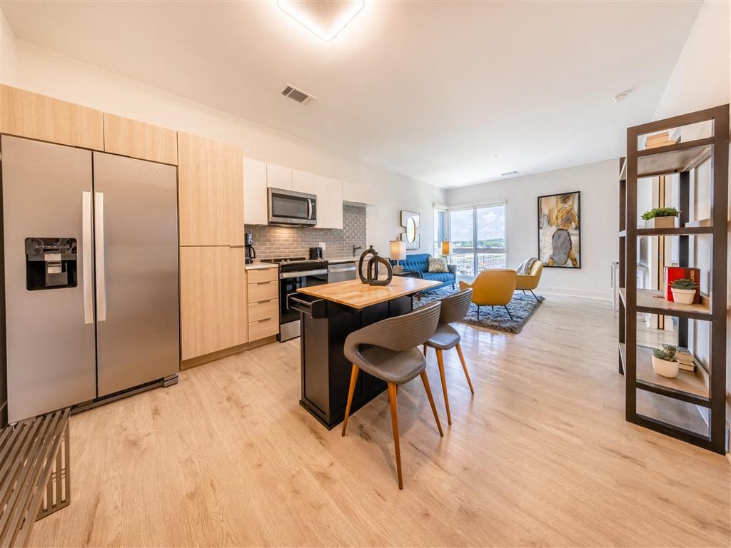 a kitchen and living room with a table and chairs