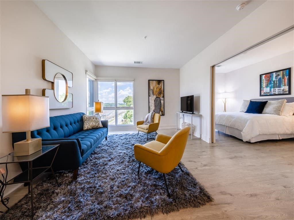 a living room with a couch and a bed in a bedroom