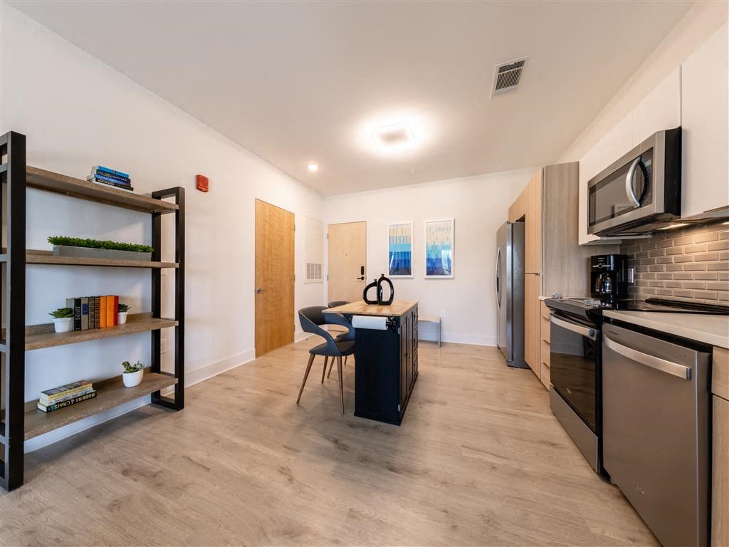 a kitchen and dining room with stainless steel appliances and a table