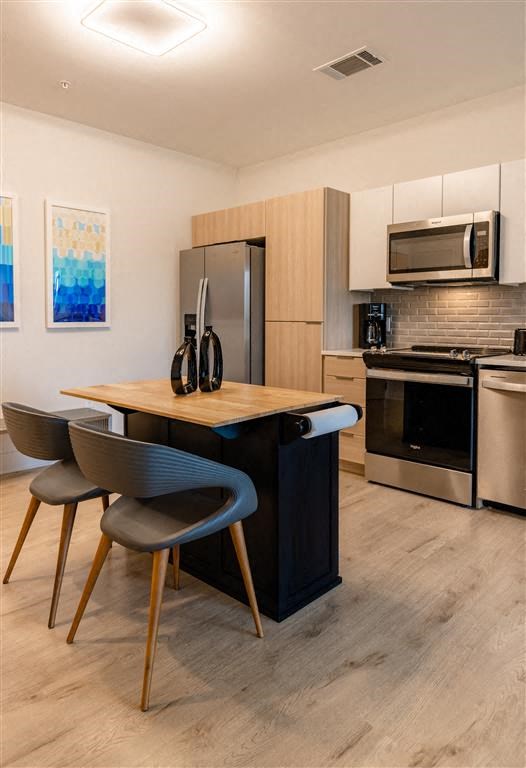 a living room with a kitchen with a table and chairs