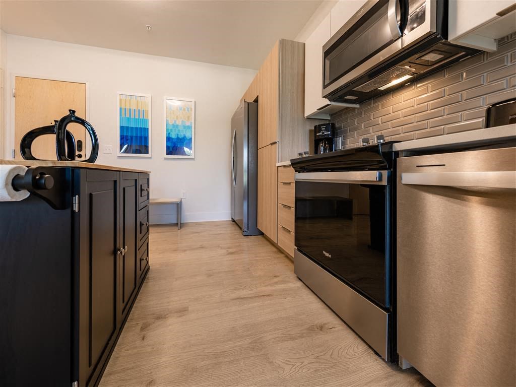 a modern kitchen with stainless steel appliances and a wood floor