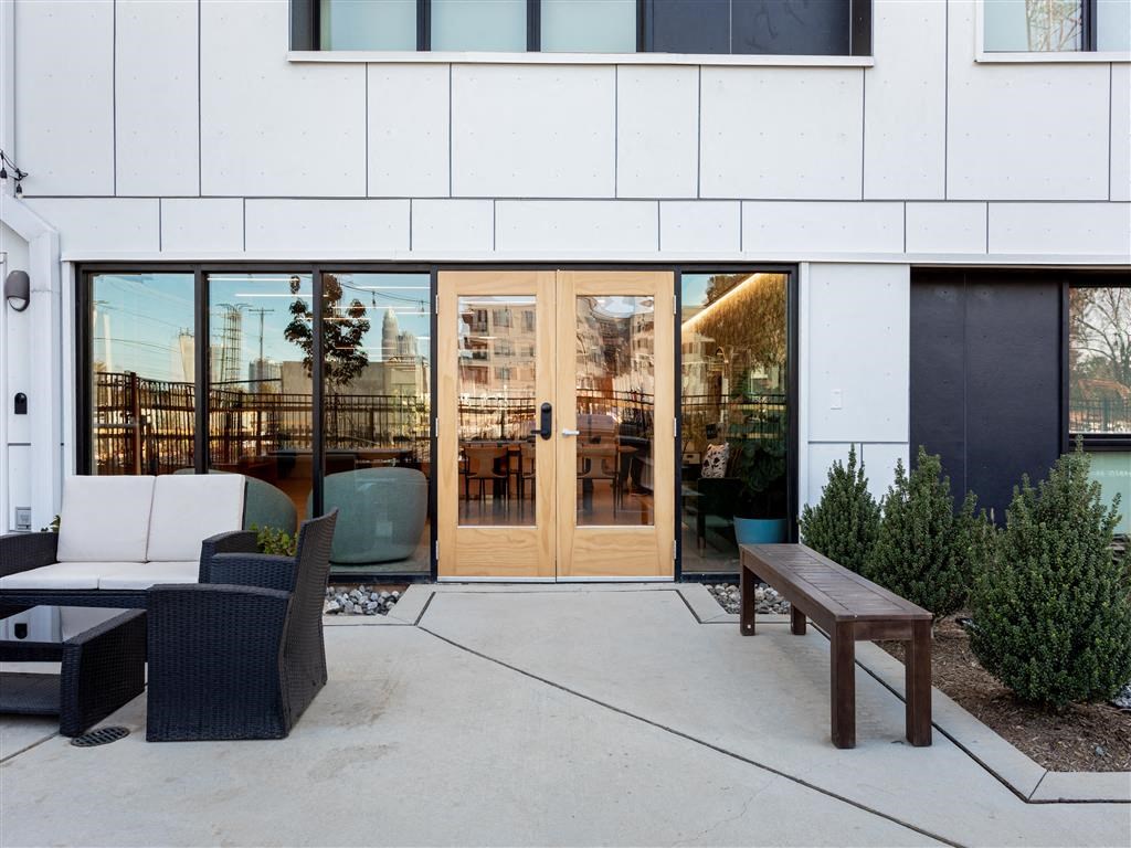 a patio with chairs and a table outside of a building