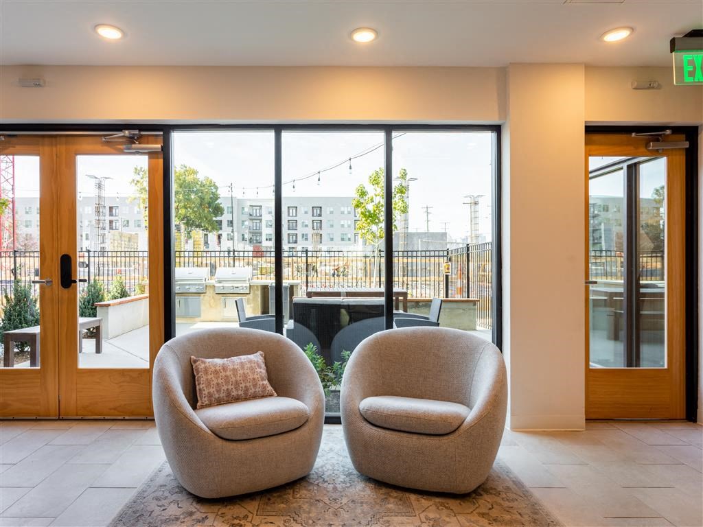 two chairs in the lobby of a building with large windows