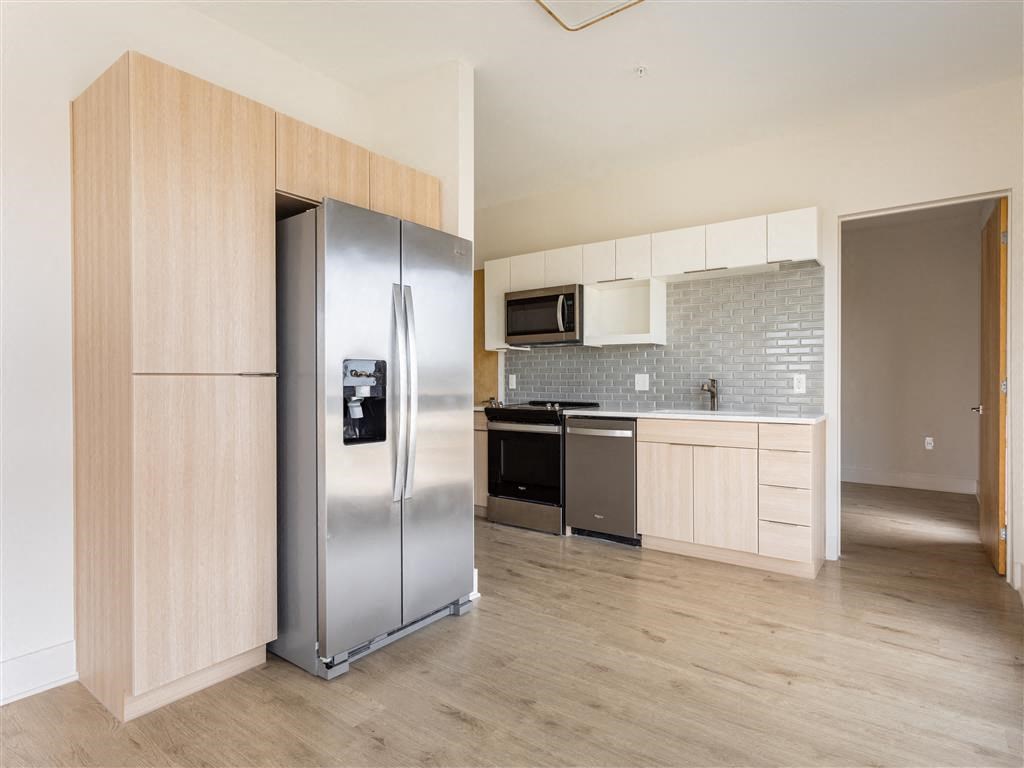 a kitchen with a stainless steel refrigerator