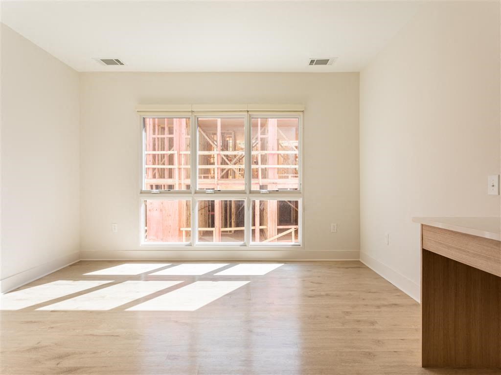 a living room with a window and a wooden floor
